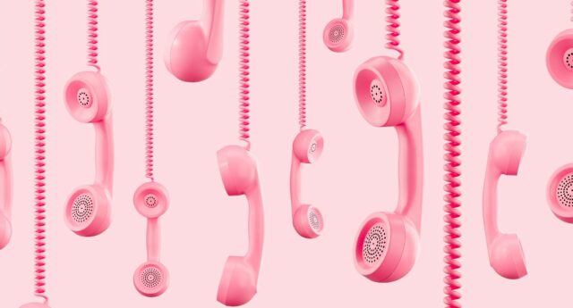 Plusieurs combines telephoniques roses suspendus sur fond rose clair