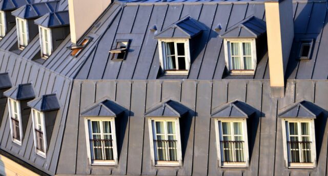 Toits en zinc et lucarnes d'immeubles haussmaniens parisiens en plein soleil