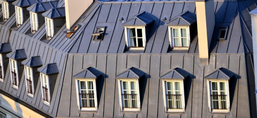 Toits en zinc et lucarnes d'immeubles haussmaniens parisiens en plein soleil