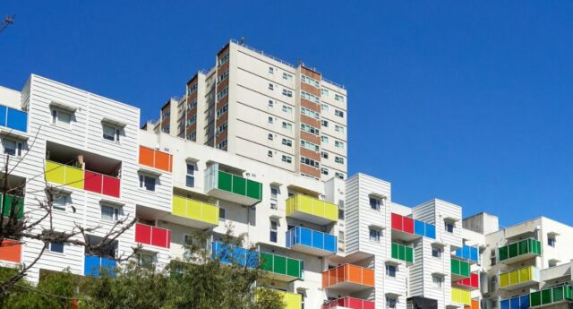 Immeuble d’habitation aux balcons colorés sous un ciel bleu