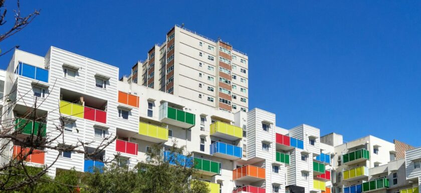 Immeuble d’habitation aux balcons colorés sous un ciel bleu