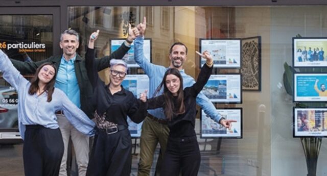 L’équipe d’une agence immobilière Côté Particuliers devant sa vitrine
