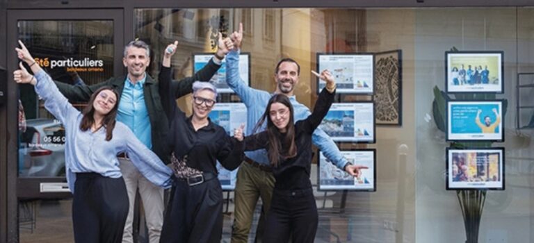 L’équipe d’une agence immobilière Côté Particuliers devant sa vitrine
