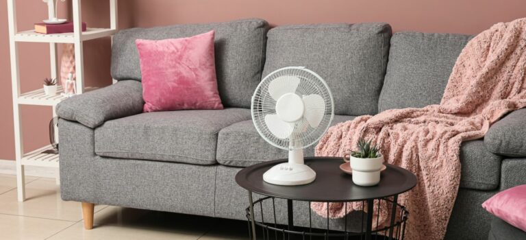 Ventilateur dans un salon aux volets partiellement fermés pendant une journée chaude