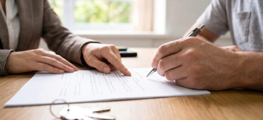 Signature d'un nouveau bail de location : un professionnel montre une clause du contrat type au locataire