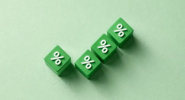 Quatre cubes verts avec un symbole de pourcentage disposés en montée sur un fond vert clair.