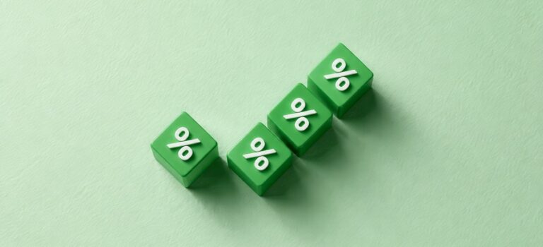 Quatre cubes verts avec un symbole de pourcentage disposés en montée sur un fond vert clair.