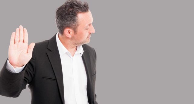 Homme levant la main pour signifier un refus