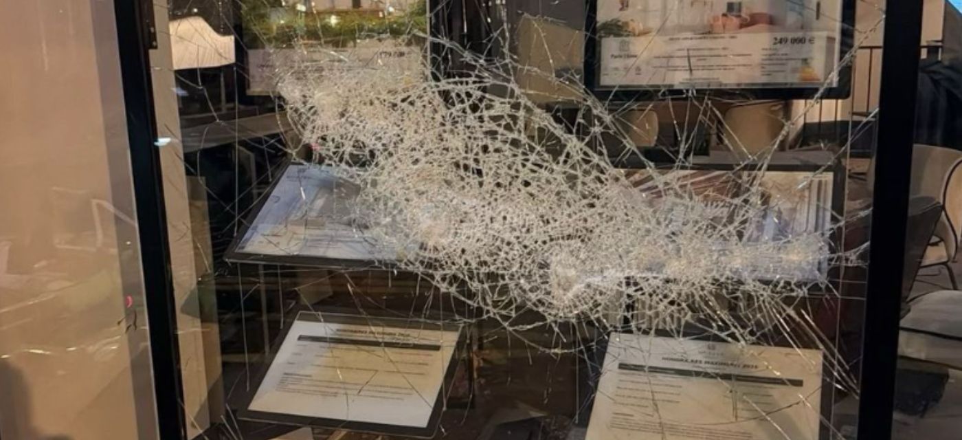 Vitrine brisée de l’agence Moriss Immobilier Voltaire à Paris après les violences du 17 octobre 2026, annonces encore affichées