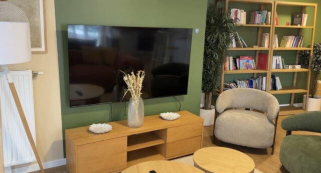 Salle TV de la résidence CRISTAL à Clichy, avec fauteuils, bibliothèque et télévision.