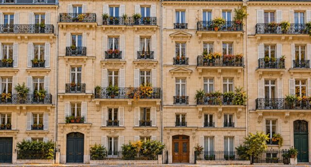 Vue large de façades d’immeubles résidentiels de style parisien, avec balcons et arbres en automne