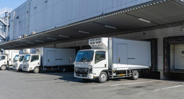 Camions stationnés devant les quais de chargement d’un entrepôt logistique
