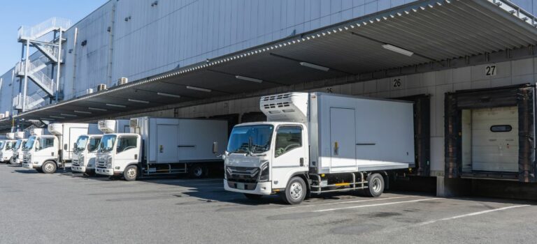 Camions stationnés devant les quais de chargement d’un entrepôt logistique