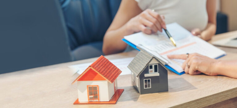 Professionnels de l’immobilier échangeant autour d’un dossier et de biens immobiliers