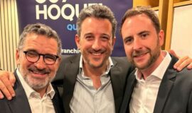 Trois hommes posent devant une signalétique Guy Hoquet Québec.