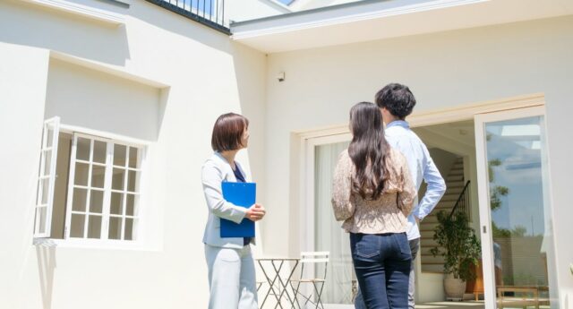 Des acquéreurs visitent un appartement ancien avec une agente immobilière.