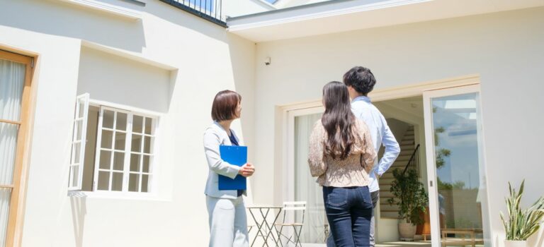Des acquéreurs visitent un appartement ancien avec une agente immobilière.