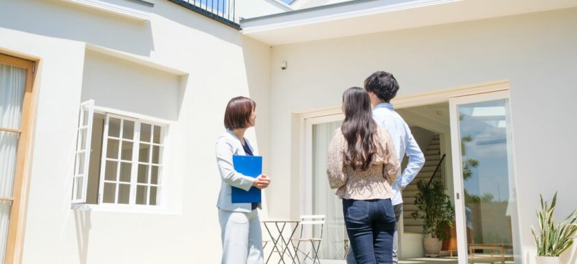 Des acquéreurs visitent un appartement ancien avec une agente immobilière.