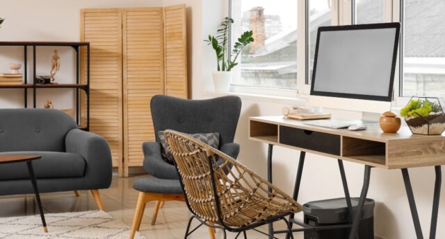 Logement meublé avec canapé, fauteuil et bureau équipé d'un ordinateur, illustrant la location meublée