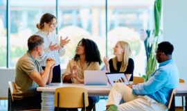 Des professionnels échangent autour d’une table dans un espace de travail lumineux