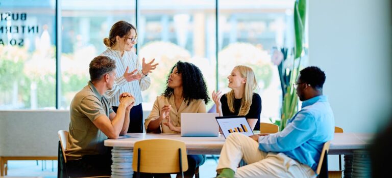 Des professionnels échangent autour d’une table dans un espace de travail lumineux
